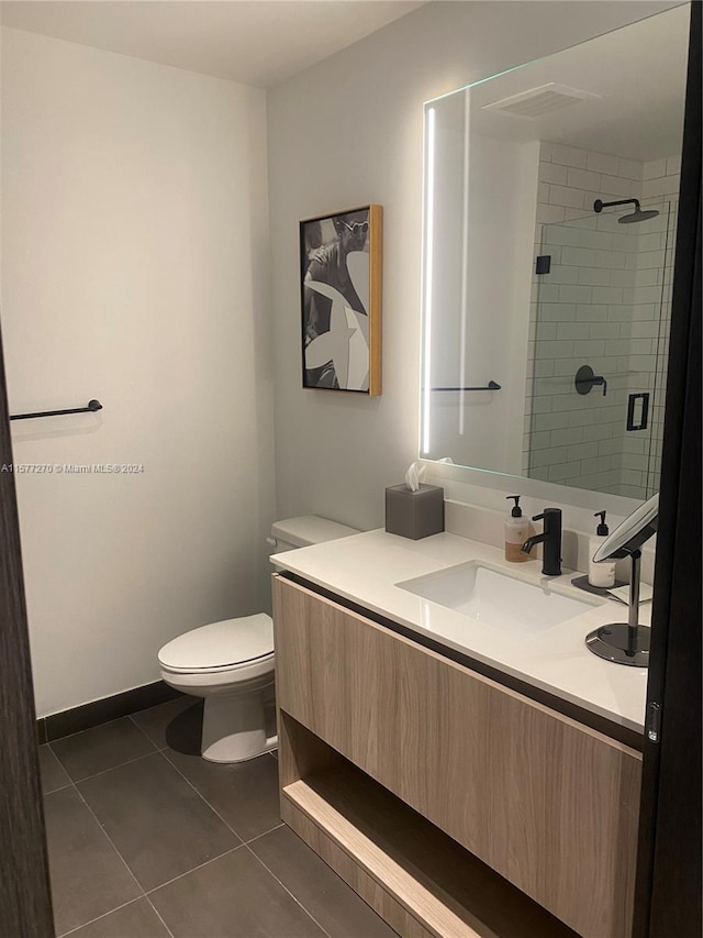 bathroom featuring tile floors, vanity, and toilet