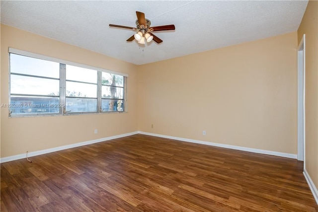 spare room with dark hardwood / wood-style flooring, ceiling fan, and a textured ceiling