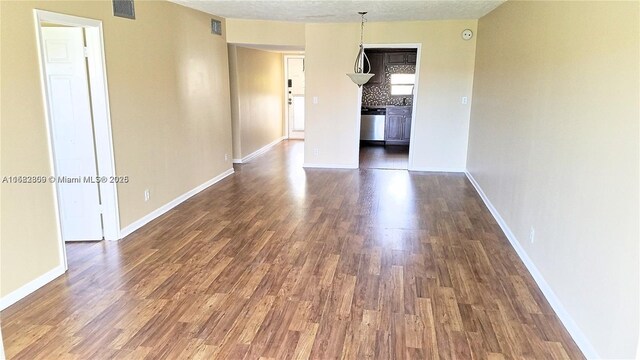 unfurnished bedroom featuring wood-type flooring, ensuite bathroom, ceiling fan, and a closet