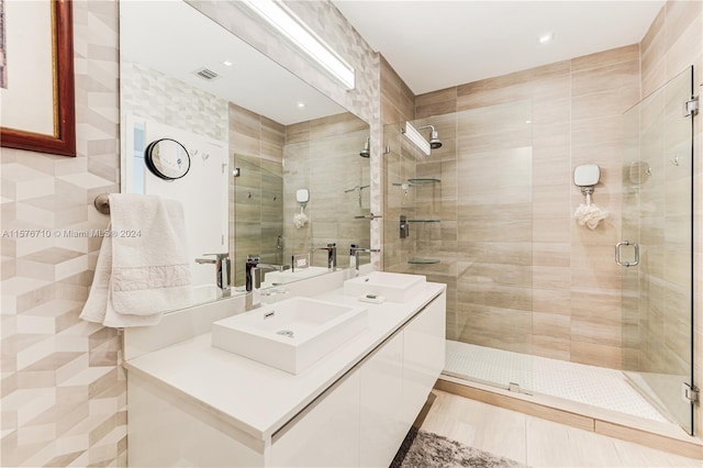 bathroom with vanity, an enclosed shower, and tile walls