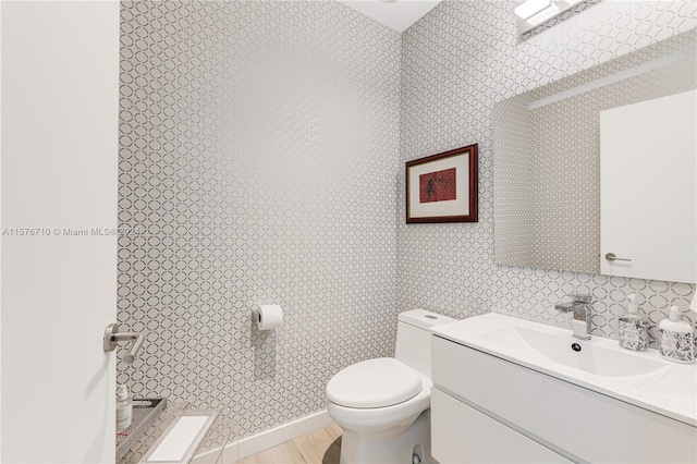 bathroom featuring hardwood / wood-style flooring, vanity, and toilet