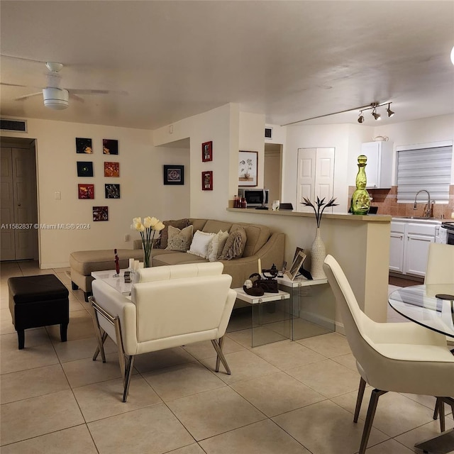 living room with sink, ceiling fan, track lighting, and light tile flooring