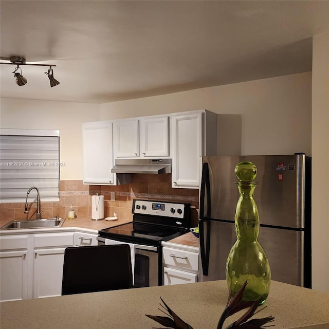 kitchen featuring white cabinets, sink, appliances with stainless steel finishes, and backsplash