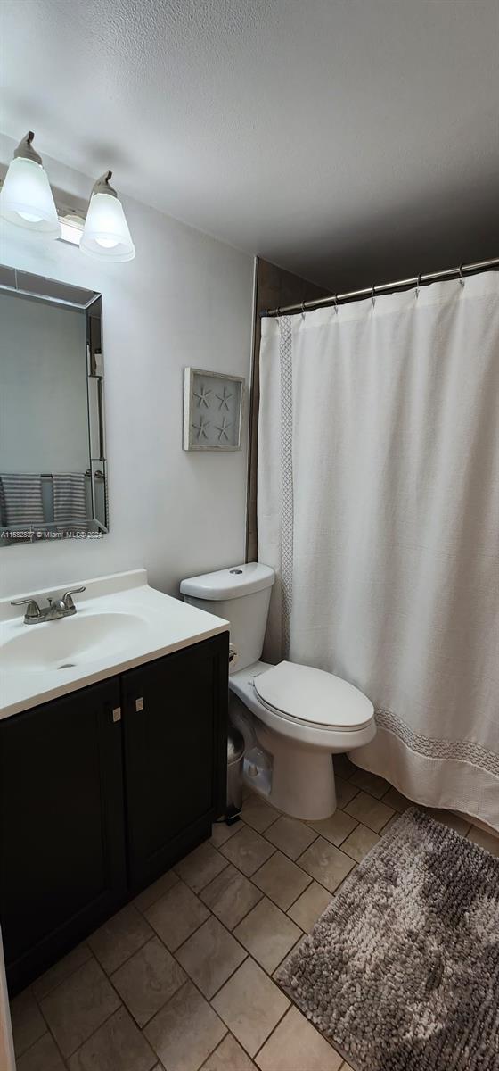 bathroom featuring tile floors, toilet, and oversized vanity