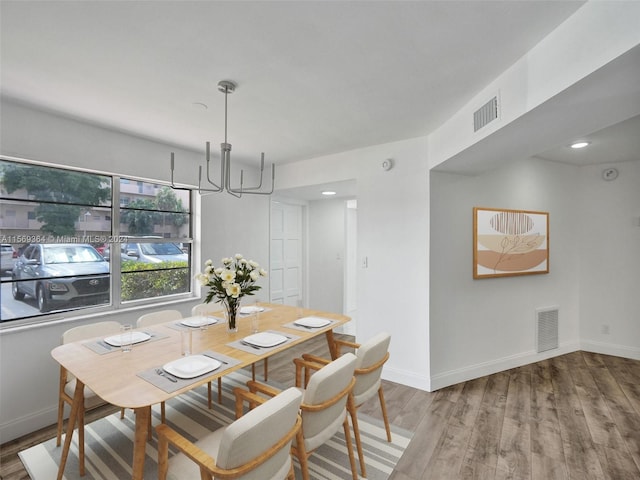 dining room with an inviting chandelier and hardwood / wood-style flooring