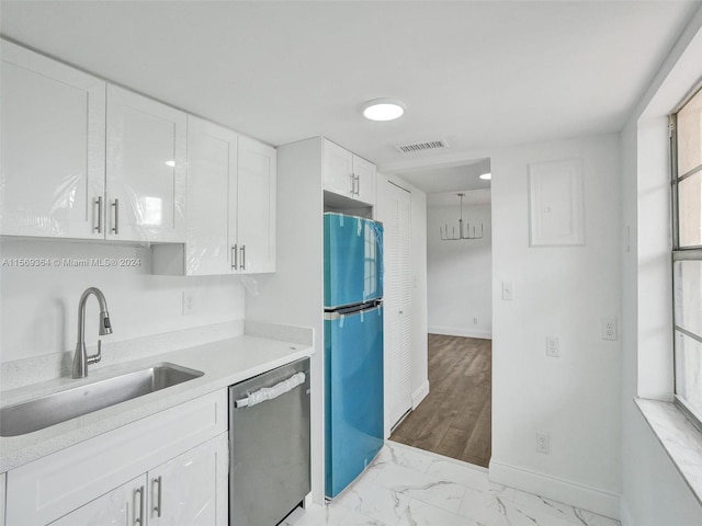 kitchen with white cabinets, stainless steel appliances, light hardwood / wood-style floors, decorative light fixtures, and sink