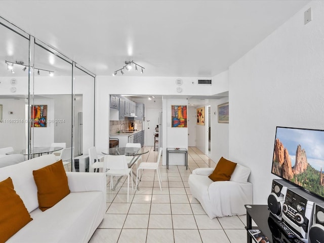 living room with sink, light tile floors, and track lighting