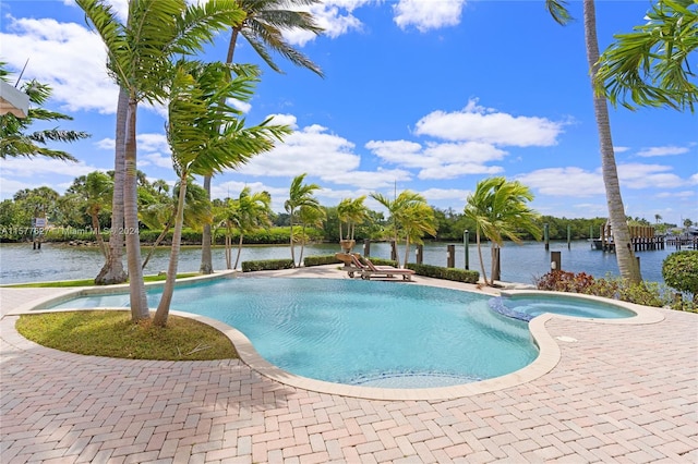 view of pool featuring a patio area, a water view, and an in ground hot tub