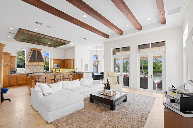 living room featuring french doors, a towering ceiling, light tile floors, and ornamental molding