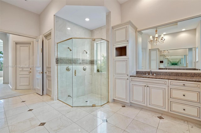 bathroom with tile floors, vanity, an enclosed shower, and a chandelier