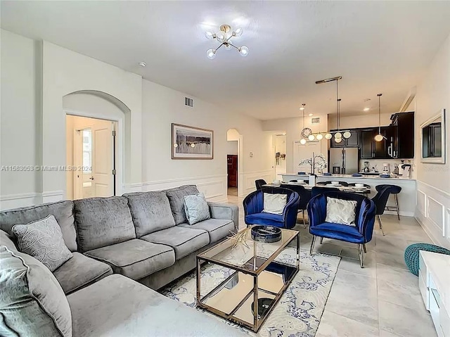 living room with a chandelier and light tile floors