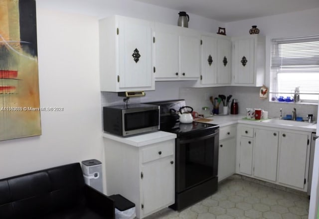 kitchen featuring white cabinets, backsplash, and black / electric stove