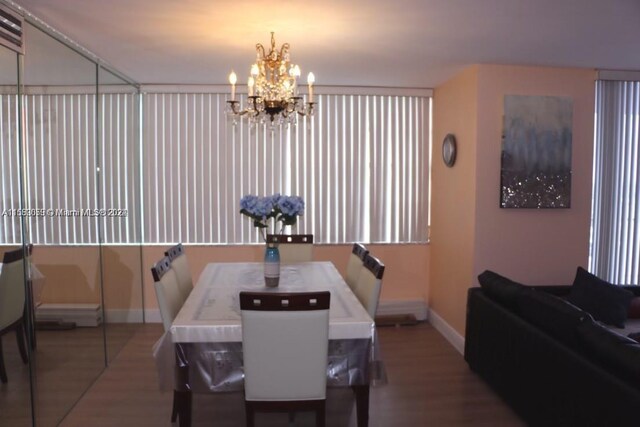 dining space with dark hardwood / wood-style floors and a notable chandelier