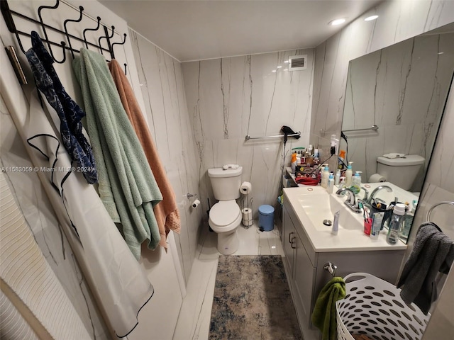 bathroom featuring vanity, toilet, walk in shower, and tile patterned flooring