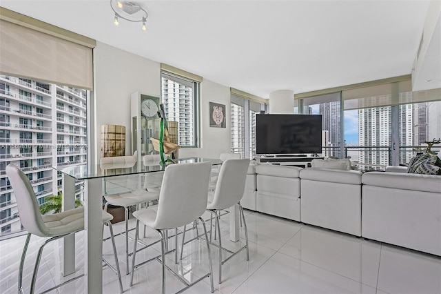 dining space featuring expansive windows and light tile patterned floors