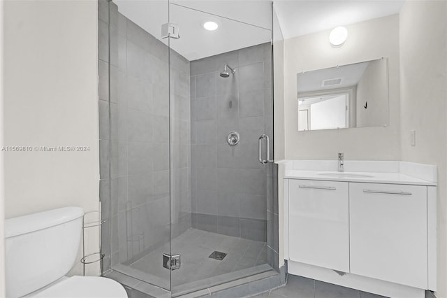 bathroom featuring tile patterned floors, vanity, toilet, and an enclosed shower