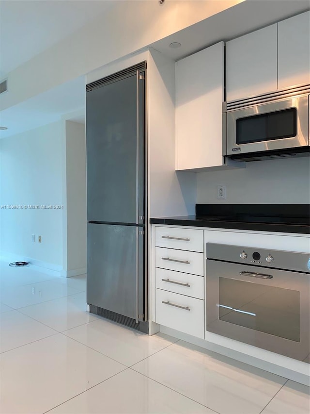 kitchen with white cabinetry, light tile patterned floors, and appliances with stainless steel finishes