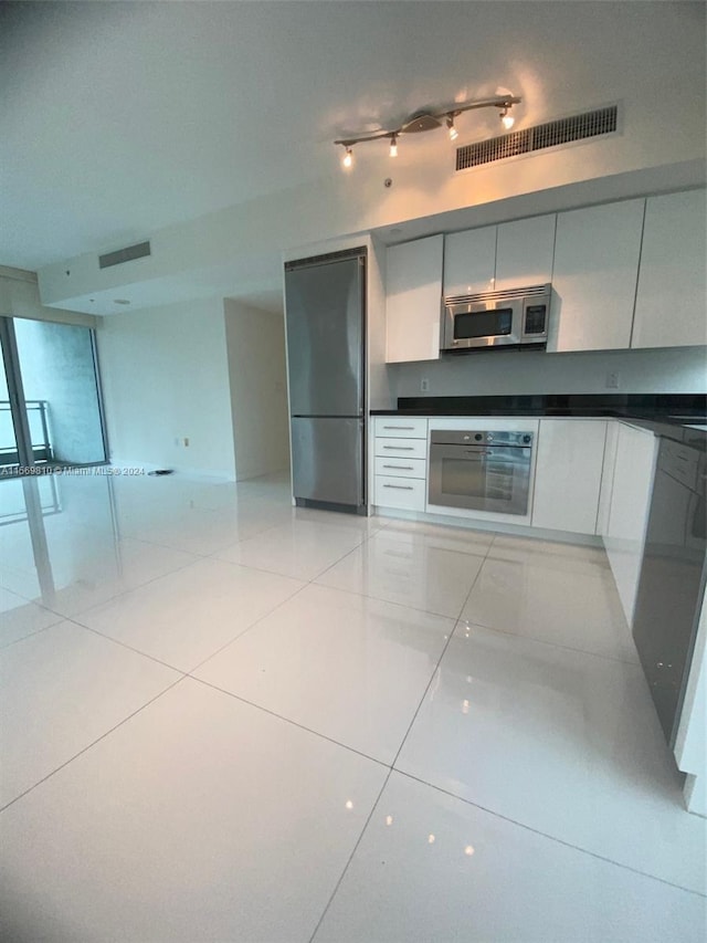 kitchen featuring stainless steel appliances and light tile patterned flooring