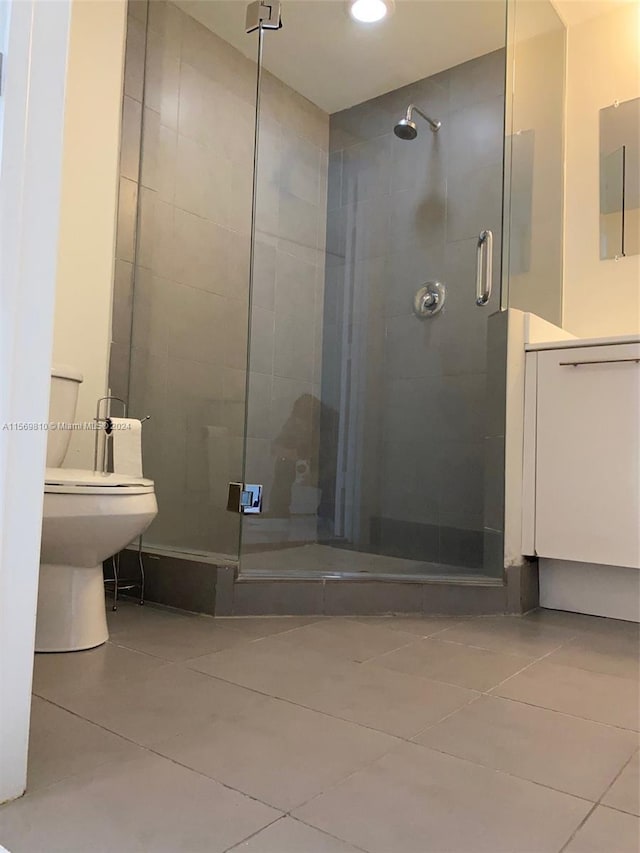 bathroom featuring walk in shower, tile patterned flooring, and toilet