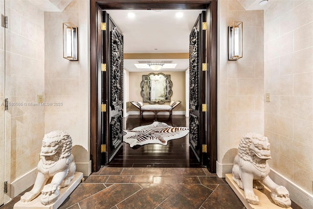 hallway with tile walls and baseboards