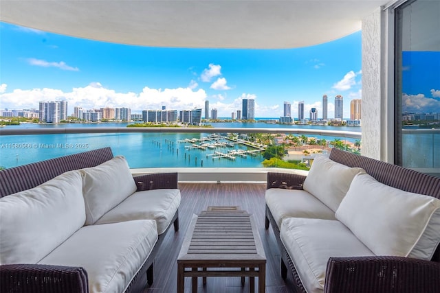 balcony featuring a water view and a city view