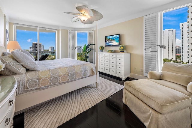 bedroom with dark wood-style floors, ceiling fan, and baseboards