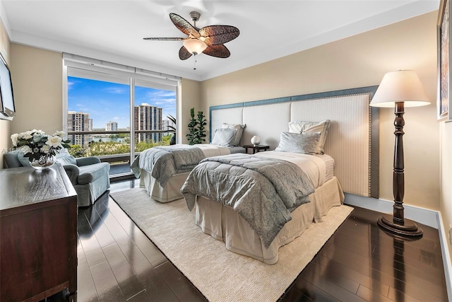 bedroom featuring ceiling fan, a view of city, floor to ceiling windows, and dark wood-style flooring