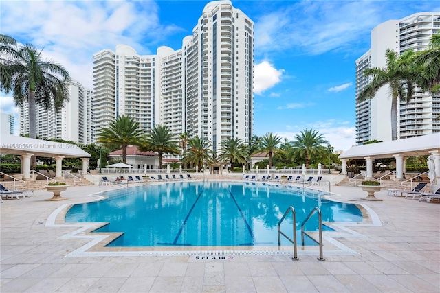 community pool with a patio area and a city view