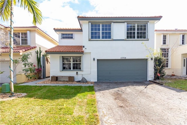 mediterranean / spanish-style home featuring a garage and a front lawn