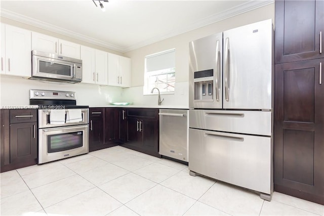 kitchen featuring appliances with stainless steel finishes, crown molding, white cabinetry, and light tile floors