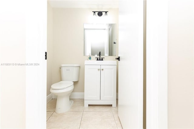 bathroom with toilet, tile flooring, and vanity