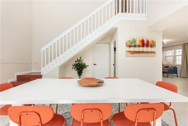 dining area featuring light tile flooring and a high ceiling