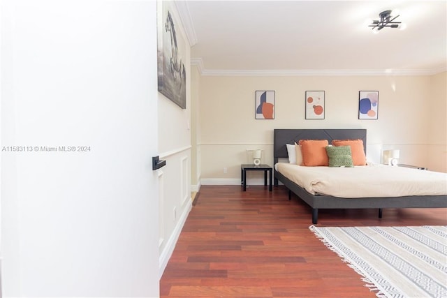 bedroom with ornamental molding and dark hardwood / wood-style flooring