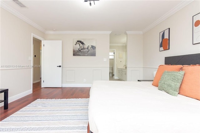 bedroom with ensuite bath, dark hardwood / wood-style floors, and crown molding