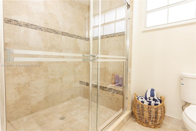 bathroom with tile floors, an enclosed shower, and toilet