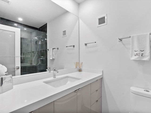 bathroom with toilet, an enclosed shower, and vanity