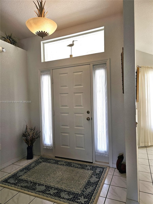 entrance foyer featuring light tile patterned floors and a textured ceiling