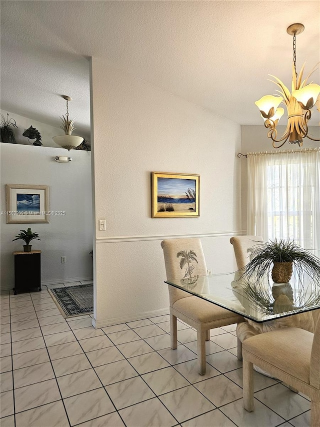 tiled dining room featuring a notable chandelier and a textured ceiling