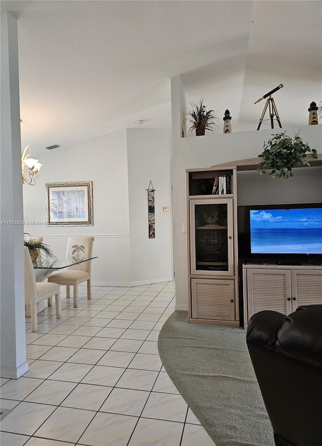 tiled living room featuring a chandelier and vaulted ceiling