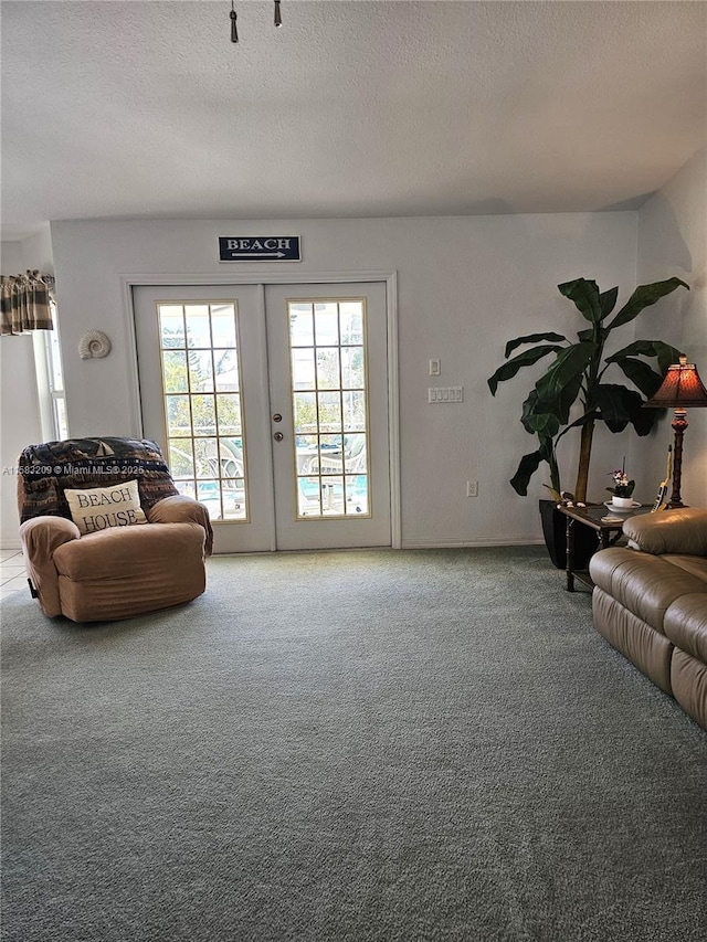 carpeted living room with french doors and a textured ceiling