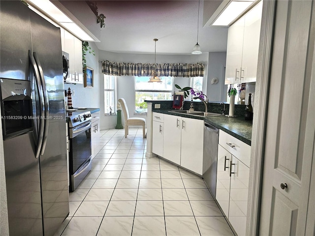 kitchen featuring sink, hanging light fixtures, light tile patterned floors, appliances with stainless steel finishes, and white cabinets