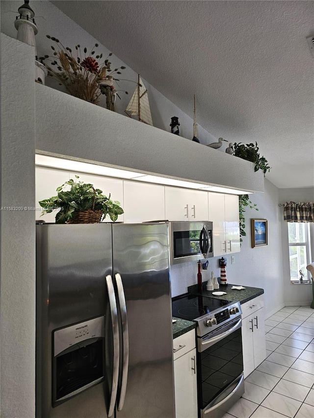 kitchen with stainless steel appliances, lofted ceiling, white cabinets, and a textured ceiling