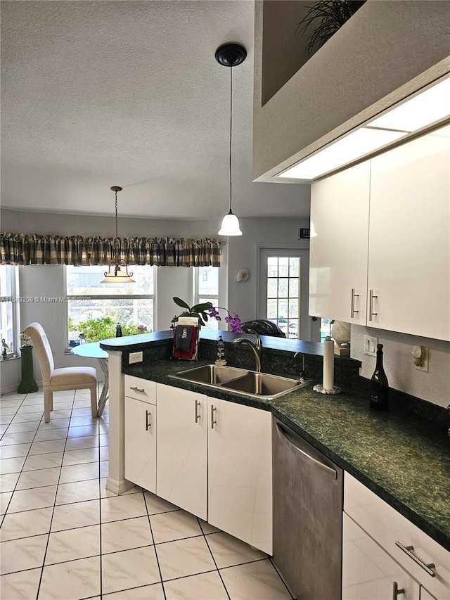 kitchen featuring stainless steel dishwasher, sink, hanging light fixtures, and white cabinets