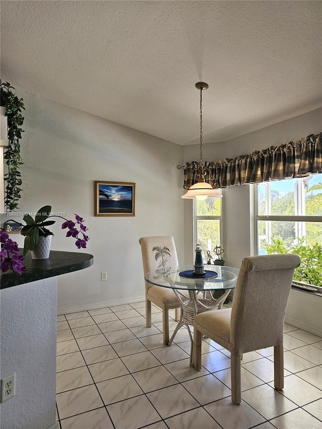 tiled dining space featuring plenty of natural light and a textured ceiling