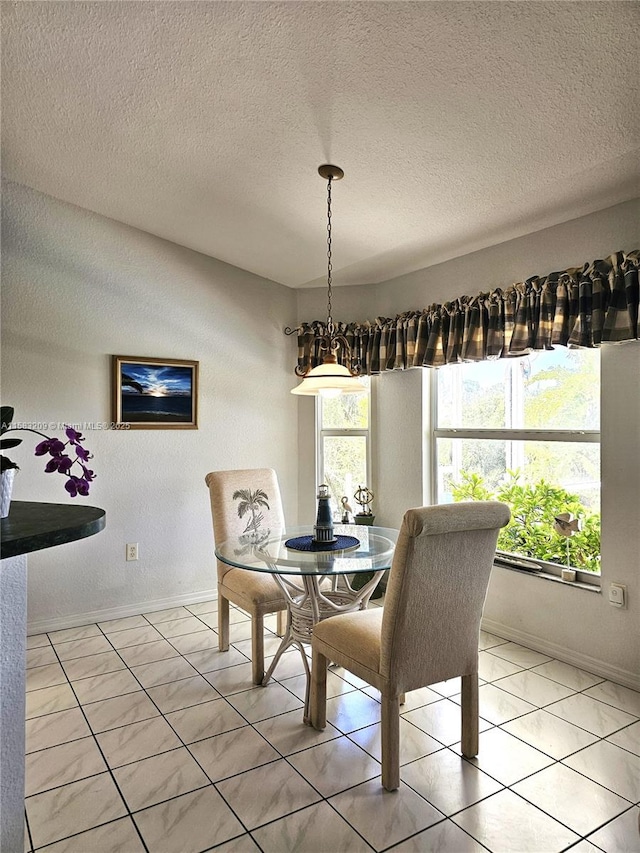 dining space with light tile patterned floors and a textured ceiling