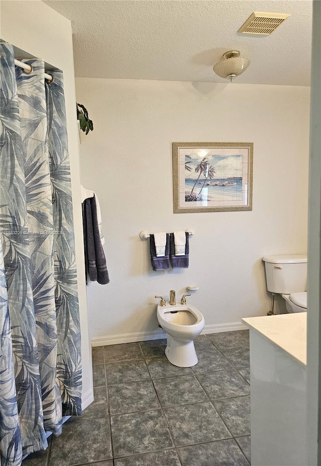 bathroom with a bidet, a textured ceiling, and a shower with shower curtain