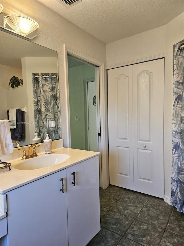 bathroom with vanity and a textured ceiling