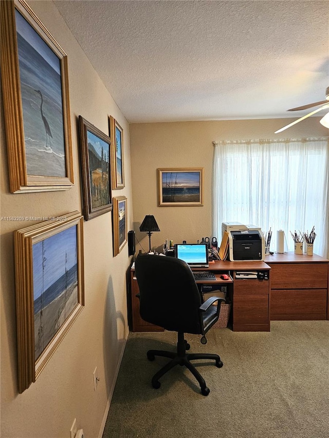 carpeted office space featuring ceiling fan and a textured ceiling