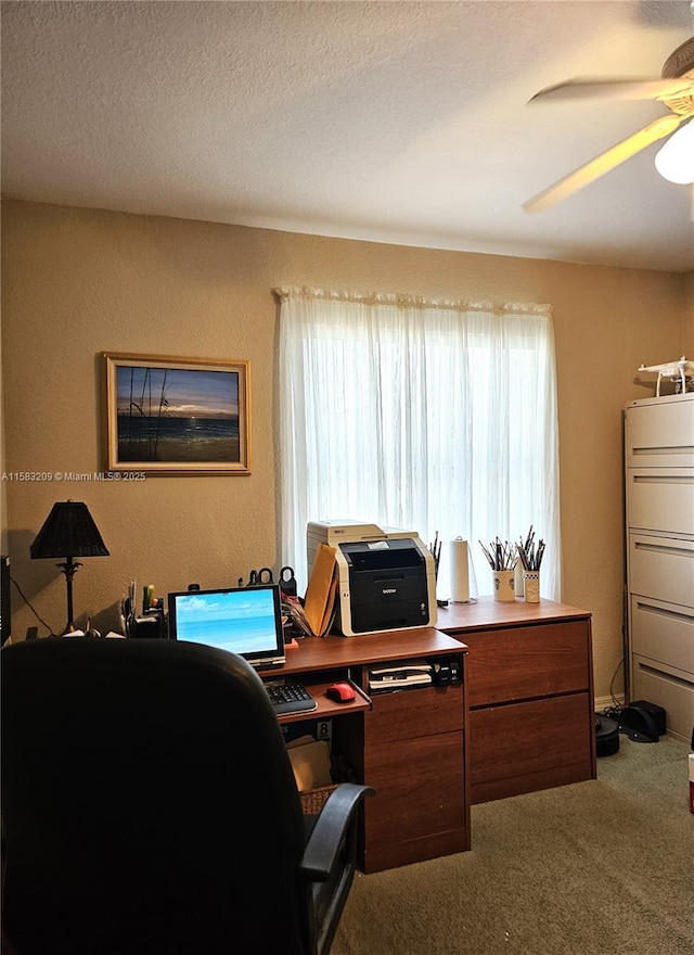 home office with ceiling fan, carpet flooring, and a textured ceiling