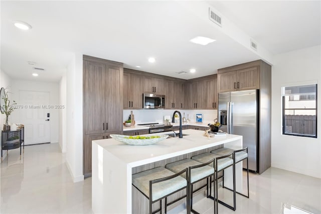 kitchen with visible vents, a breakfast bar, recessed lighting, stainless steel appliances, and light countertops